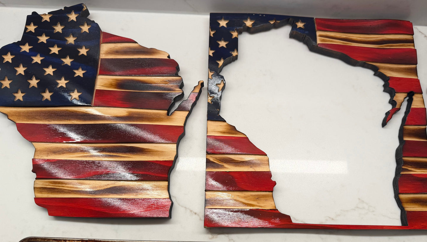Wooden crafts shaped like the state of Wisconsin with American flag design on a white surface.